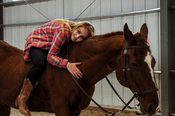 Alissa laying on a horse