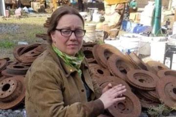 woman with glasses posing in front of metal objects