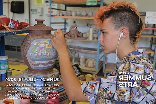 woman decorating a ceramic vase